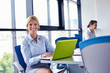 business woman with her staff in background at office