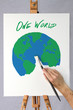 Artist painting a picture of the earth on a canvas