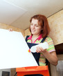 Woman glues ceiling tile