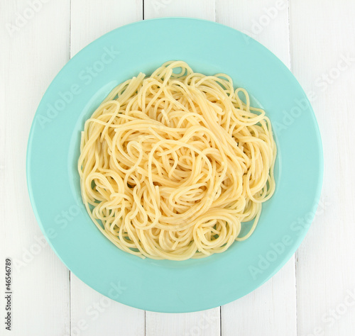 Photo: Italian spaghetti in plate on wooden table Italian spaghetti in plate on wooden table