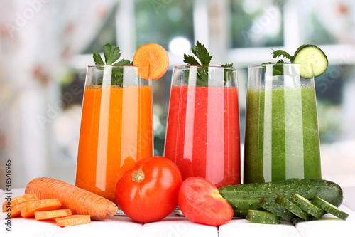 Photo: Fresh vegetable juices on wooden table, on window background Fresh vegetable juices on wooden table, on window background
