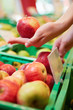 Hand hält Apfel im Supermarkt