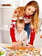 Mother and children rolling dough in the kitchen.