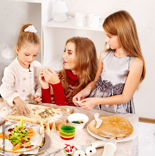 Photo: Mother and children rolling dough in the kitchen. Mother and children rolling dough in the kitchen.