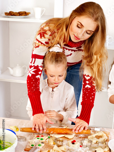 Photo: Mother and children rolling dough in the kitchen. Mother and children rolling dough in the kitchen.