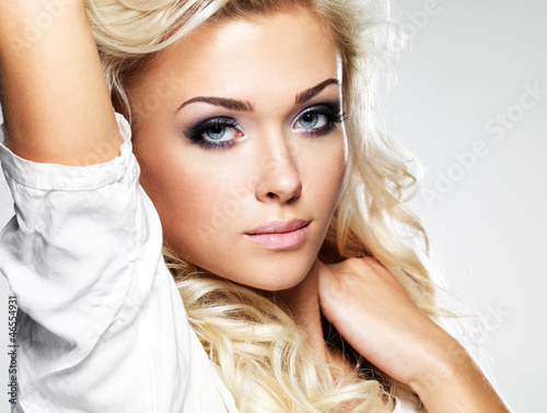 Photo: Beautiful blond woman with long curly hair and style makeup. Beautiful blond woman with long curly hair and style makeup.