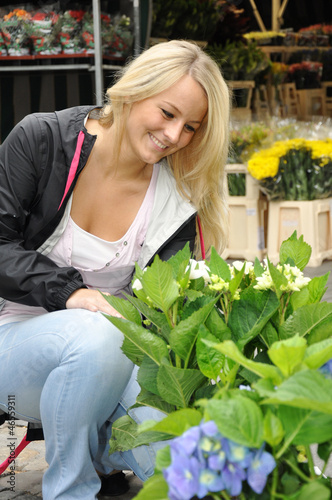 Photo: Junge Frau kauft Blumen auf Markt Junge Frau kauft Blumen auf Markt