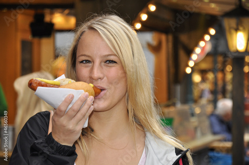 Photo: Junge Frau isst Bratwurst Junge Frau isst Bratwurst