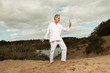Senior spiritual man dressed in white. Exercising outdoors.