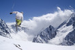 Photo: Freestyle ski jumper with crossed skis in high mountains Freestyle ski jumper with crossed skis in high mountains
