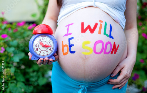Photo: portrait of pretty young woman expecting a baby,outdoors, portrait of pretty young woman expecting a baby,outdoors,