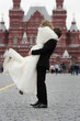 Happy groom holding young beautiful bride in his arms