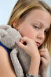 Fillette blonde triste avec doudou