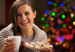 Happy woman holding cup of hot chocolate with marshmallows