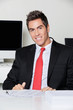 Happy Businessman Sitting At Desk