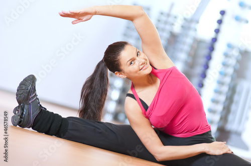 Photo: Woman doing stretching exercises at the gym Woman doing stretching exercises at the gym