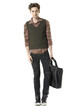 Casual man holding handbag walking posing in the studio