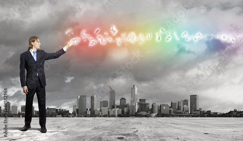 Photo: Image of a business man standing against cityscape Image of a business man standing against cityscape