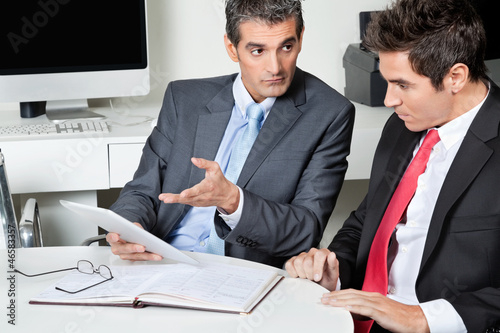 Photo: Businessmen Using Digital Tablet At Desk Businessmen Using Digital Tablet At Desk