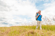 Photo: Young girl walking in meadow with backpack on. Young girl walking in meadow with backpack on.