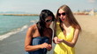 Female friends collecting shells on the beach, steadicam shot 