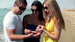 Group of friends collecting shells on the beach, steadicam shot 