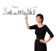 Young woman drawing famous cities and landmarks on whiteboard