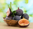 Ripe sweet figs with leaves in basket,