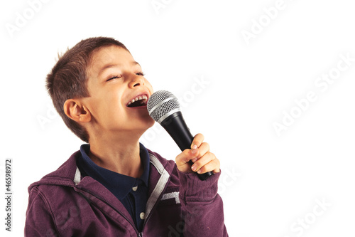 Photo: Child singing with microphone, isolated on white background. Child singing with microphone, isolated on white background.
