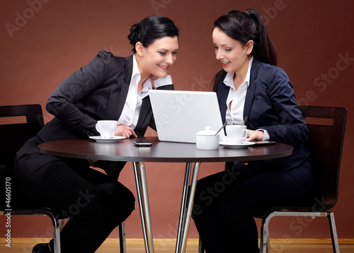 Photo: Two 20s business women with laptop and coffee 2 Two 20s business women with laptop and coffee 2