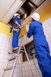 Man and woman repairing ventilation system