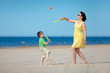 Young mother and son playing on the beach