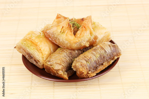 Photo: Sweet baklava on plate on bamboo mat Sweet baklava on plate on bamboo mat