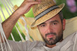 Man relaxing in hammock whilst on holiday
