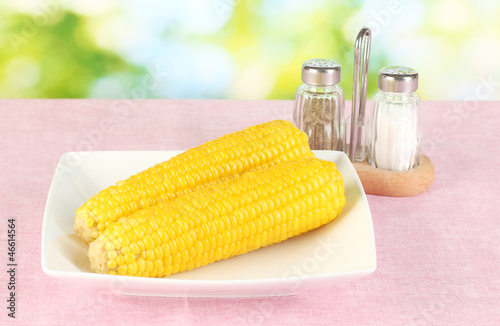 Photo: boiled corn on the pink table cloths on the background of boiled corn on the pink table cloths on the background of