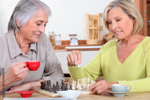 Photo: Mother and daughter playing chess Mother and daughter playing chess