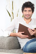Man sat reading on sofa