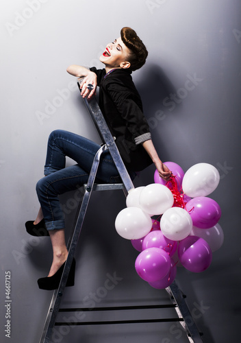 Photo: Pretty cheerful fashion retro teen girl laughing on ladder Pretty cheerful fashion retro teen girl laughing on ladder