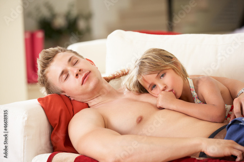 Photo: Father And Daughter Relaxing On Sofa Father And Daughter Relaxing On Sofa