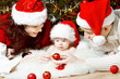 Christmas family with baby in red hats giving gifts