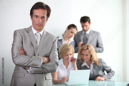 Photo: male executive with his team of colleagues male executive with his team of colleagues