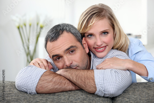 Photo: A nice couple cuddling on a couch. A nice couple cuddling on a couch.