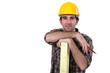 Construction worker posing with a wooden plank