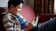 Young teenager playing games on tablet computer