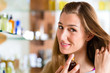 woman buying perfume in shop or store