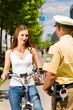 Frau auf Fahrrad mit Polizist in Kontrolle