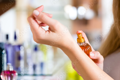 Photo: woman buying perfume in shop or store woman buying perfume in shop or store