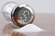 Salt spilling from glass salt shaker