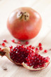 Vertical shot of a pomegranate and grains on wooden boards