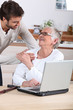 man explaining to senior woman how to use computer